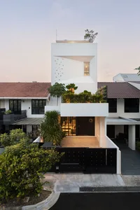 White-rendered exterior of a modern house with a garden.