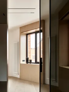 A modern interior design featuring a wooden window with a view of a neighboring building.