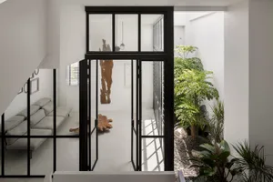 A modern living room with transparent glass windows, showcasing a minimalist design.