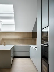 A modern kitchen with white marble countertops and stainless steel appliances.