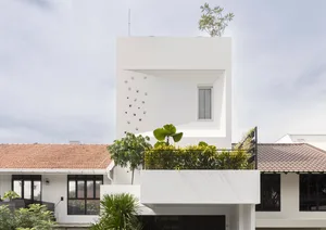 Modern residential exterior featuring white walls and glass windows.