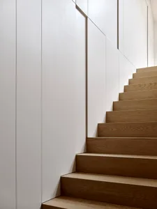 A modern staircase with wooden steps and metallic railings.