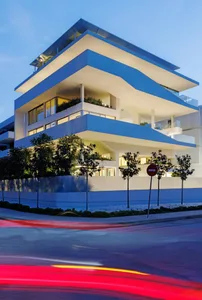 A modern apartment building constructed with concrete and glass materials.
