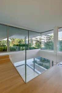 Modern architectural design featuring a glass staircase with wood flooring.