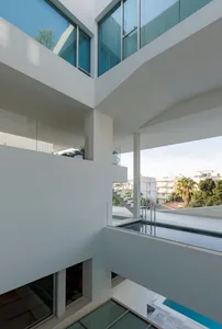 Modern residential area featuring a pool, glass walls, and concrete structures.