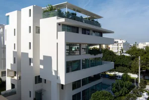 Modern residential apartment building with concrete and glass exterior.