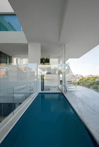 Modern swimming pool featuring concrete columns and blue water.