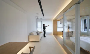 現代簡約客廳，配有白色家具、木質地板與白色天花板。