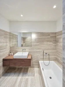 A modern bathroom with marble walls and floor.