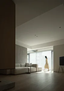 Modern minimalist living room with neutral tones, large windows, and a sleek, contemporary sofa.