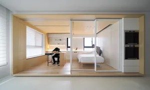 A minimalist apartment with white walls, natural pine, and modern lighting features.