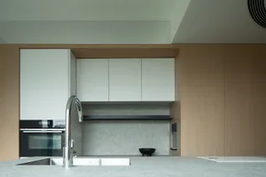 A modern kitchen featuring sleek, minimalist design in concrete and wood materials.