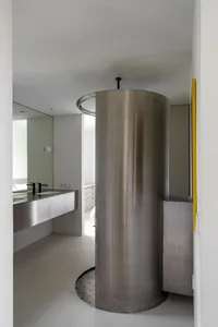 A minimalist bathroom with a stainless steel tower
