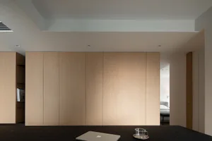 Minimalist living room featuring wooden cabinets.