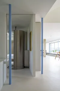 Modern interior space featuring a concrete pillar, glass doors, and metal accents.