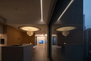 Modern minimalist kitchen with white marble countertop, wooden cabinetry, and glass fixtures.