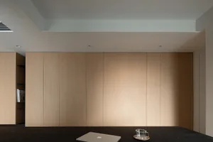 An office space featuring modern office furniture, a wooden wall paneling system, and minimalistic decor.