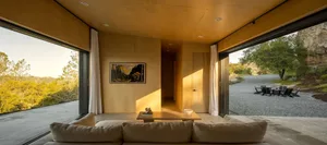 A minimalist living room with concrete and glass features, showcasing modern design elements.