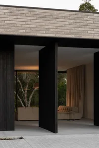 A modern living room with concrete walls and floor, featuring a cozy sofa and floor lamp.