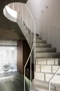 Modern concrete staircase with white railings in an interior space.