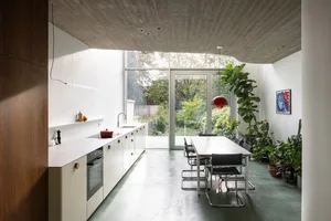 A sleek, modern kitchen with minimalist design features and a concrete floor.