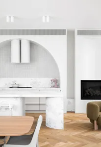 A modern kitchen featuring a white marble countertop and arch-shaped structure.