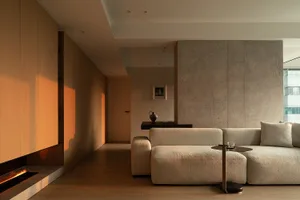Modern, minimalist living room featuring concrete walls and a wooden sofa.