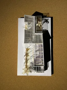 Scale model of a modern building with metal roofing and structural features.