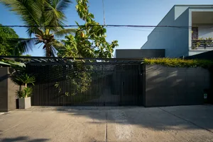 Modern design black metal security gate with concrete slabs.