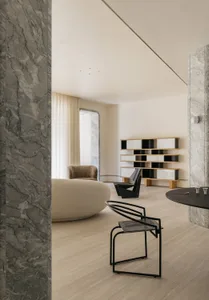 Modern living room featuring marble walls and a cozy seating area.