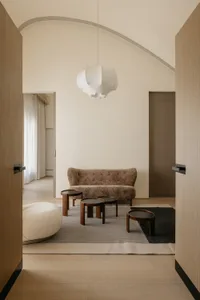 A modern living room with neutral-colored furniture on a wooden floor.