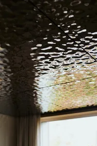 A textured ceiling reflecting a water surface with ripples and light effects.
