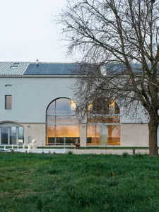 A modern house exterior featuring large glass windows