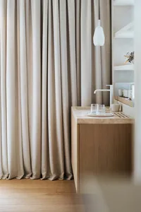 Modern bathroom with marble countertop, sink, and pendant light.