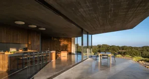Modern residential kitchen featuring wood, glass, and concrete materials.