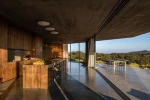 A modern residential kitchen with concrete and wooden elements
