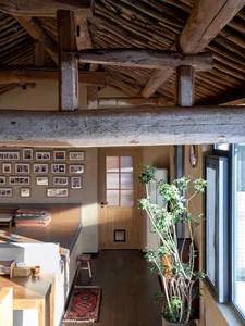 Traditional wooden loft space with an exposed beam ceiling, wooden flooring, and a window.