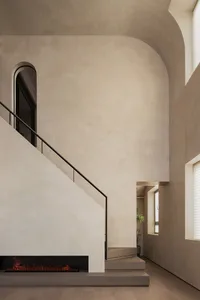 Modern interior design featuring concrete stairs with a sleek black handrail.