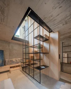 A modern living space featuring concrete, light-wood, and glass materials.