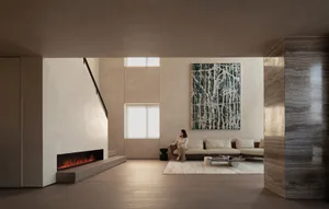 A modern minimalist living room featuring concrete and marble materials, with a woman sitting on a sofa.