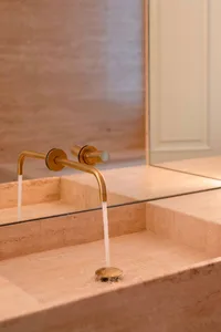 Minimalist bathroom with brass faucet and marble sink