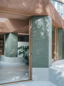 Modern interior design featuring a grand atrium entrance with granite columns and concrete flooring.
