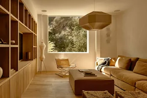 Modern living room with minimalist design, large window, and natural light.