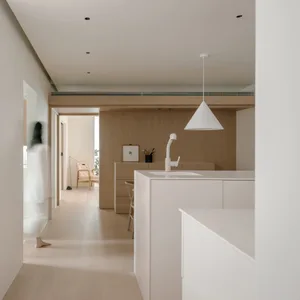 Modern minimalist kitchen featuring light wood finishes and simple design elements.