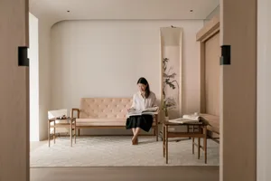 A minimalist living room with a wooden floor, leather sofa, and modern furnishings.