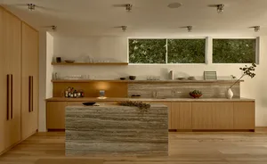 Modern minimalist kitchen featuring wood cabinetry, marble countertops, and a central marble island.