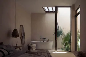 Modern minimalist bathroom featuring a concrete bathtub and a view into an indoor garden.