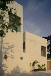 A modern residential building with a concrete facade, minimalistic design, and large windows.