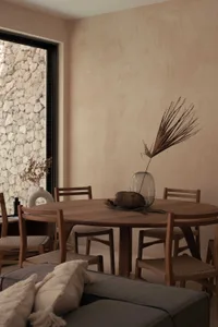 A contemporary dining room featuring minimalist design elements with wooden furniture and natural stone accents.