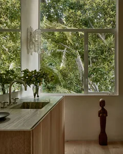 Modern kitchen with marble countertop, wooden furniture, and glass shelving